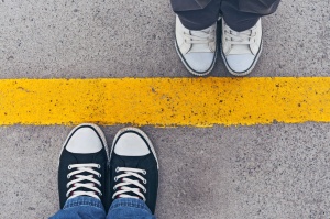 Sneakers from above. Male and female feet in sneakers from above standing at dividing line.
